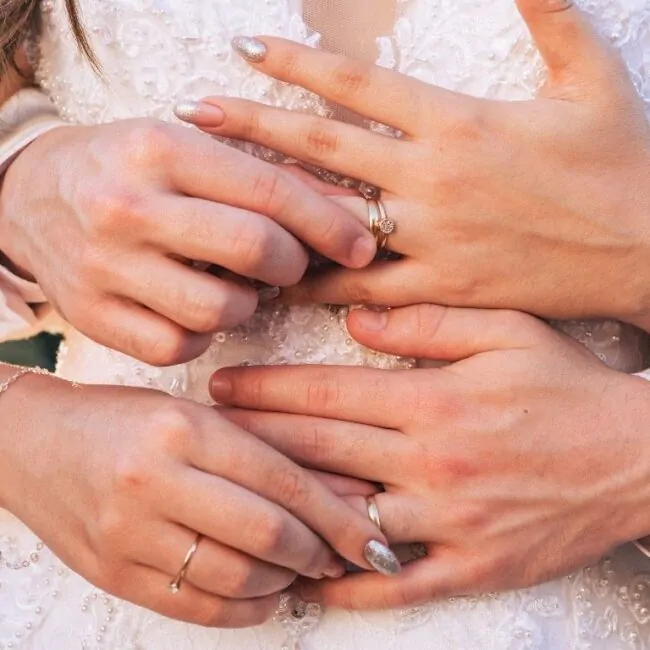 casal de noivos abraçados tocando as alianças um do outro