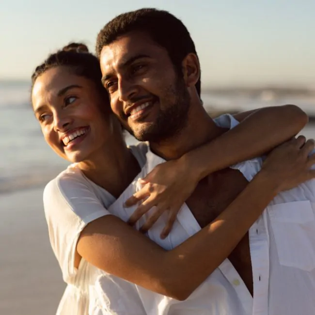 casal se abraçando na praia