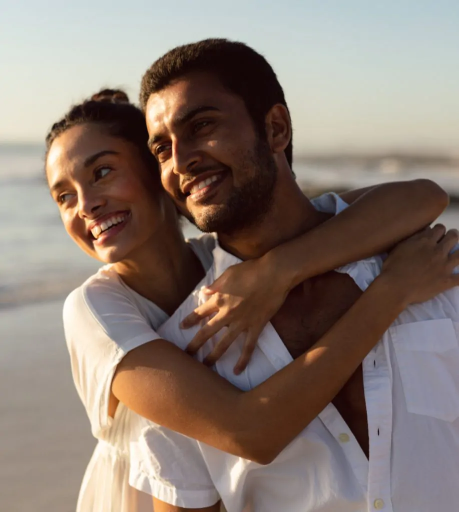 casal se abraçando na praia