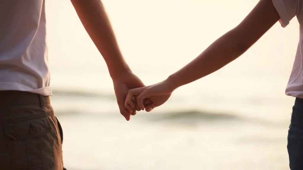 o que é adoçamento amoroso: casal de mãos dadas.