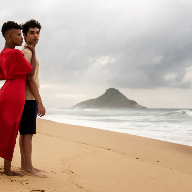 Amarração amorosa: casal em pé na areia da praia.